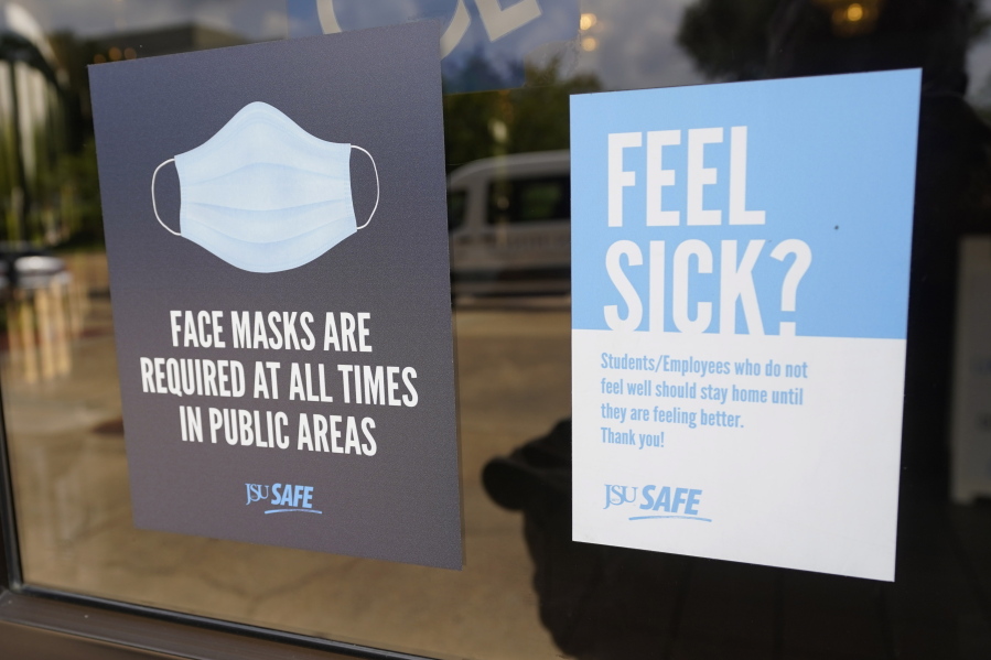 Face mask requirements are posted at the various entrances at the Rose E. McCoy Auditorium where COVID-19 vaccinations are being offered on the Jackson State University campus in Jackson, Miss., Tuesday, July 27, 2021. The university has similar signage posted throughout the campus. The Centers for Disease Control and Prevention announced new recommendations that vaccinated people return to wearing masks indoors in parts of the U.S. where the coronavirus is surging and also recommended indoor masks for all teachers, staff, students and visitors to schools, regardless of vaccination status. (AP Photo/Rogelio V.