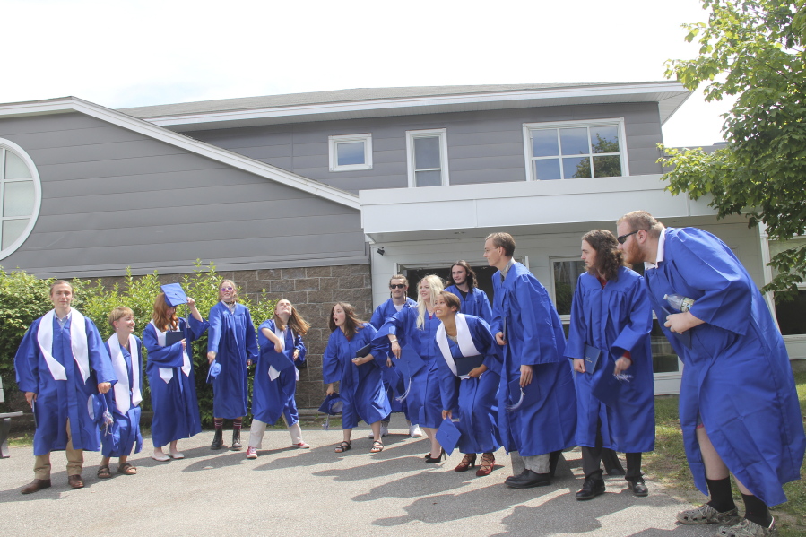 In this June 13, 2021 photo provided by Melissa Burns, Islesboro Central School seniors prepare to toss their mortarboards to celebrate their graduation. The Class of 2021 - all 13 of them - were eyeing a trip to Greece, or maybe South Korea, but they wound up going nowhere. The seniors decided to donate $5,000 to help out struggling neighbors after the coronavirus pandemic changed everything.