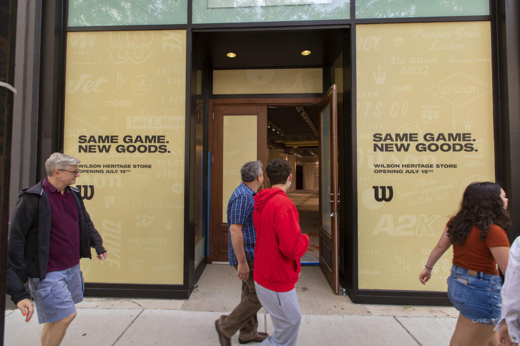Pedestrians walk past Wilson Sporting Goods on North Rush Street in Chicago, July 2, 2021. The store is under construction and will be the chain's first Chicago store upon opening on July 15.