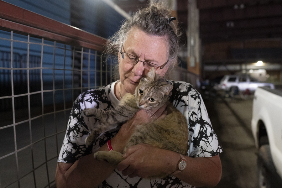 Dee McCarley hugs her cat Bunny, whom she took with her while evacuating from the Bootleg Fire, while at a Red Cross center on Wednesday, July 14, 2021 in Klamath Falls, Ore.