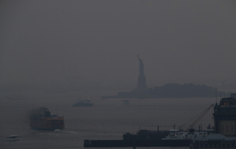 The Staten Island Ferry departs from the Manhattan terminal through a haze of smoke with the Statue of Liberty barely visible, Tuesday, July 20, 2021, in New York. Wildfires in the American West, including one burning in Oregon that's currently the largest in the U.S., are creating hazy skies as far away as New York as the massive infernos spew smoke and ash into the air in columns up to six miles high.