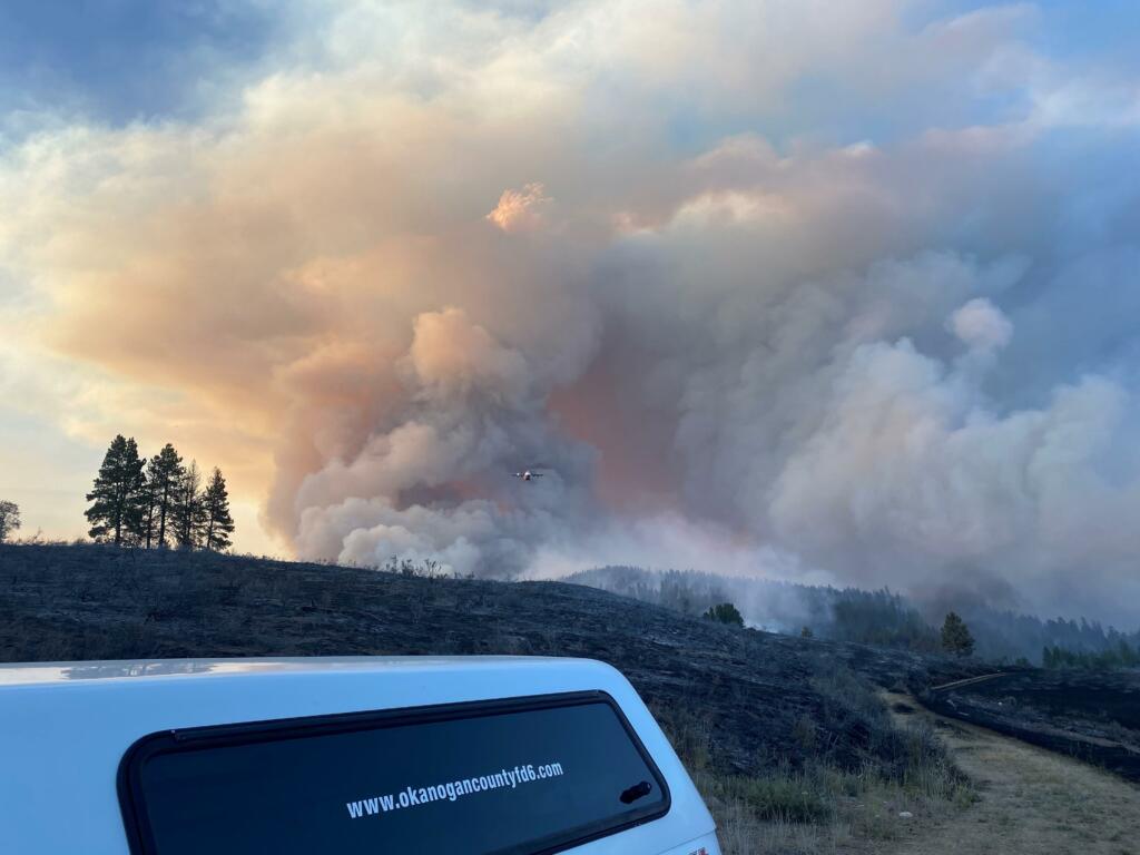 Okanogan County Fire District 6 personnel monitor aerial firefighting operations in the 32,000-acre Cub Creek Fire north of Winthrop. The fire is among those billowing smoke over popular Washington hiking trails.