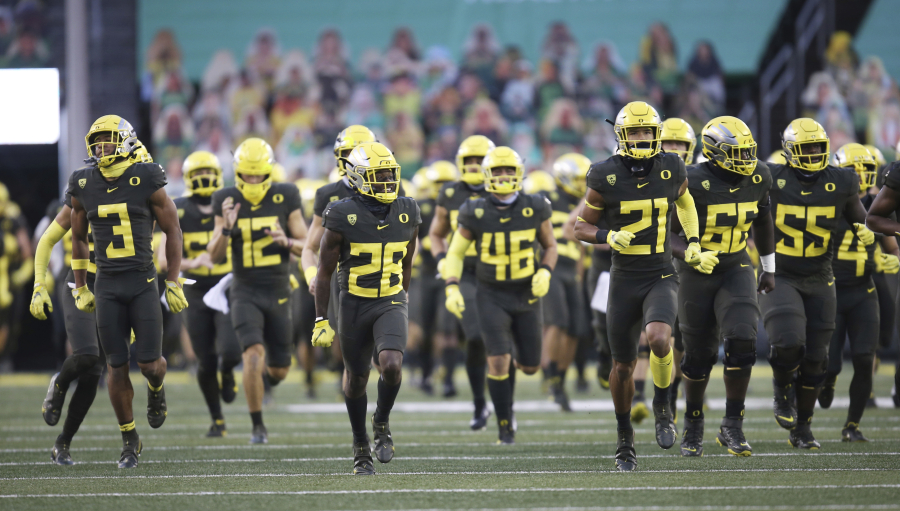 Oregon players take the field at an empty Autzen Stadium for an NCAA college football game Saturday, Nov. 7, 2020, in Eugene, Ore.