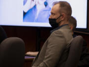 Defendant David Bogdanov listens to the prosecution's opening statement, with a photo of 17-year-old Nikki Kuhnhausen on a projection screen behind him, at his murder trial in Clark County Superior Court.