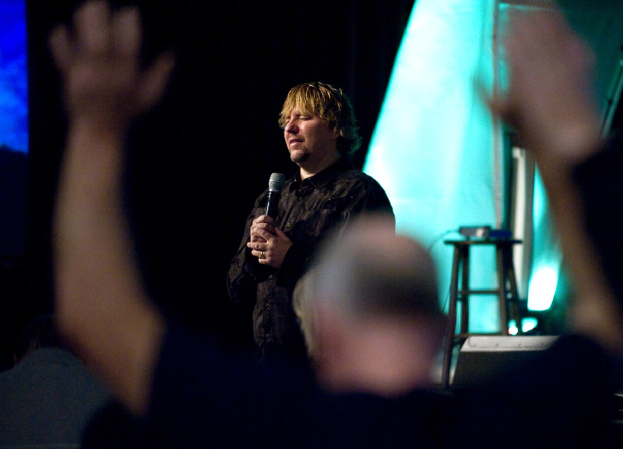 John Bishop leads a prayer during a staff meeting at Living Hope Church on Oct. 21, 2011.