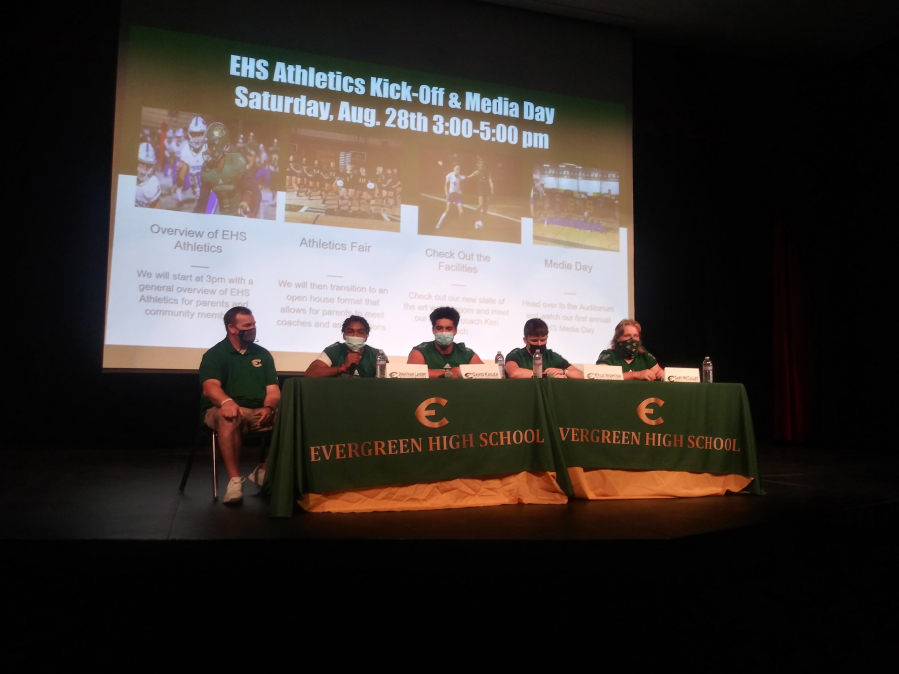 Evergreen High School football coach and athletic director Christian Swain sits with football players (from left) Jonathan Landry, David Kailea, Kyle Norton and Gary McCulley at Evergreen's Athletics Kick-off and Media Day.