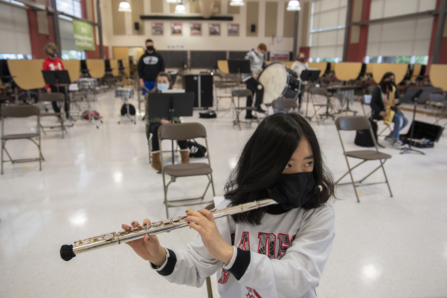 Valyssa Nguyen wears a specialized band mask and a cover on the end of her flute for COVID-19 protections during band class back in the spring at Laurin Middle School. Most of Clark County's school districts begin the 2021-22 school year next week, and mask wearing is required for all employees and students inside school buildings. That also includes specialized masks for performing arts classes and activities.