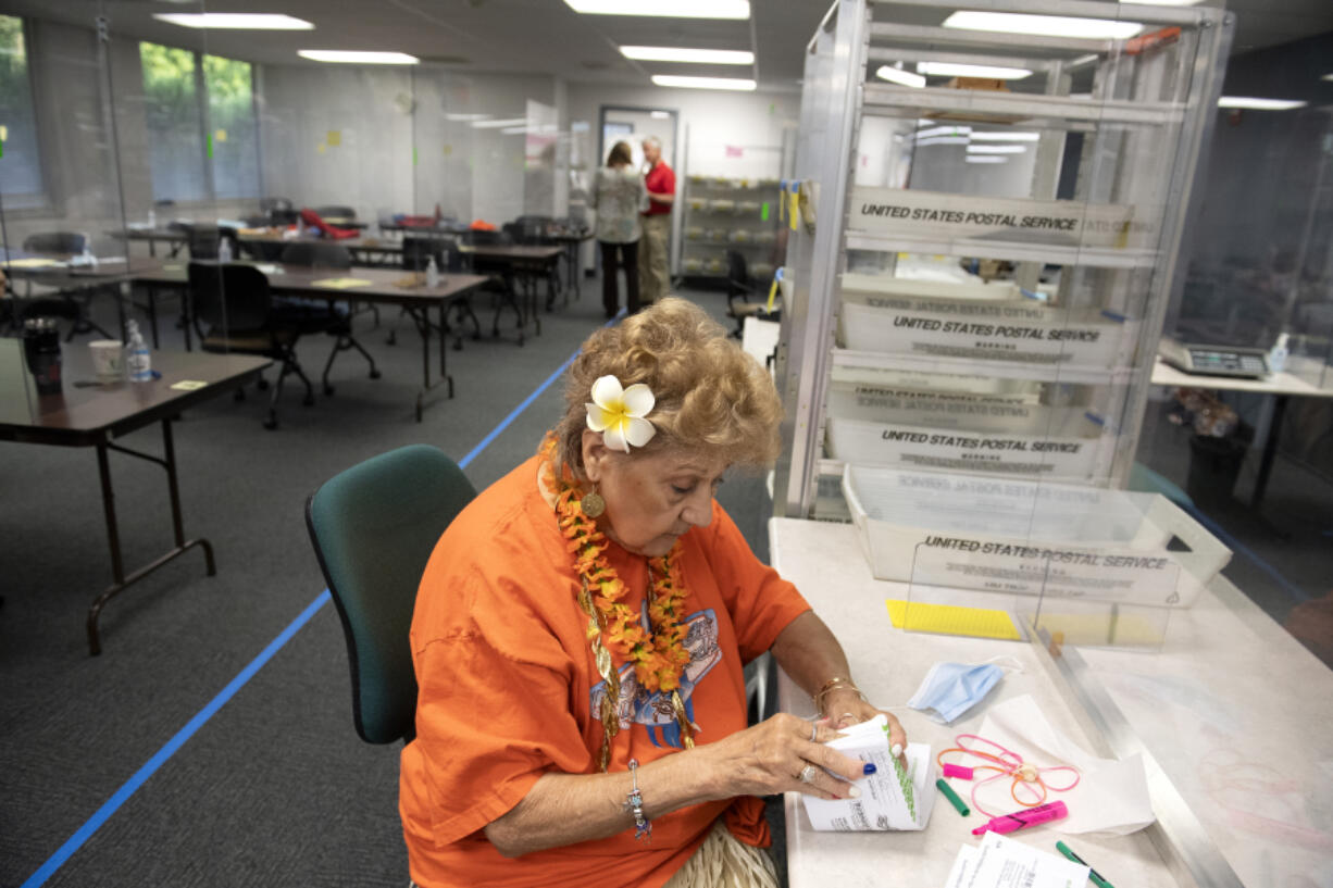 Elections office employee Josie Karling inspects ballots at the Clark County Elections Office on Tuesday morning.
