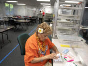 Elections office employee Josie Karling inspects ballots at the Clark County Elections Office on Tuesday morning.