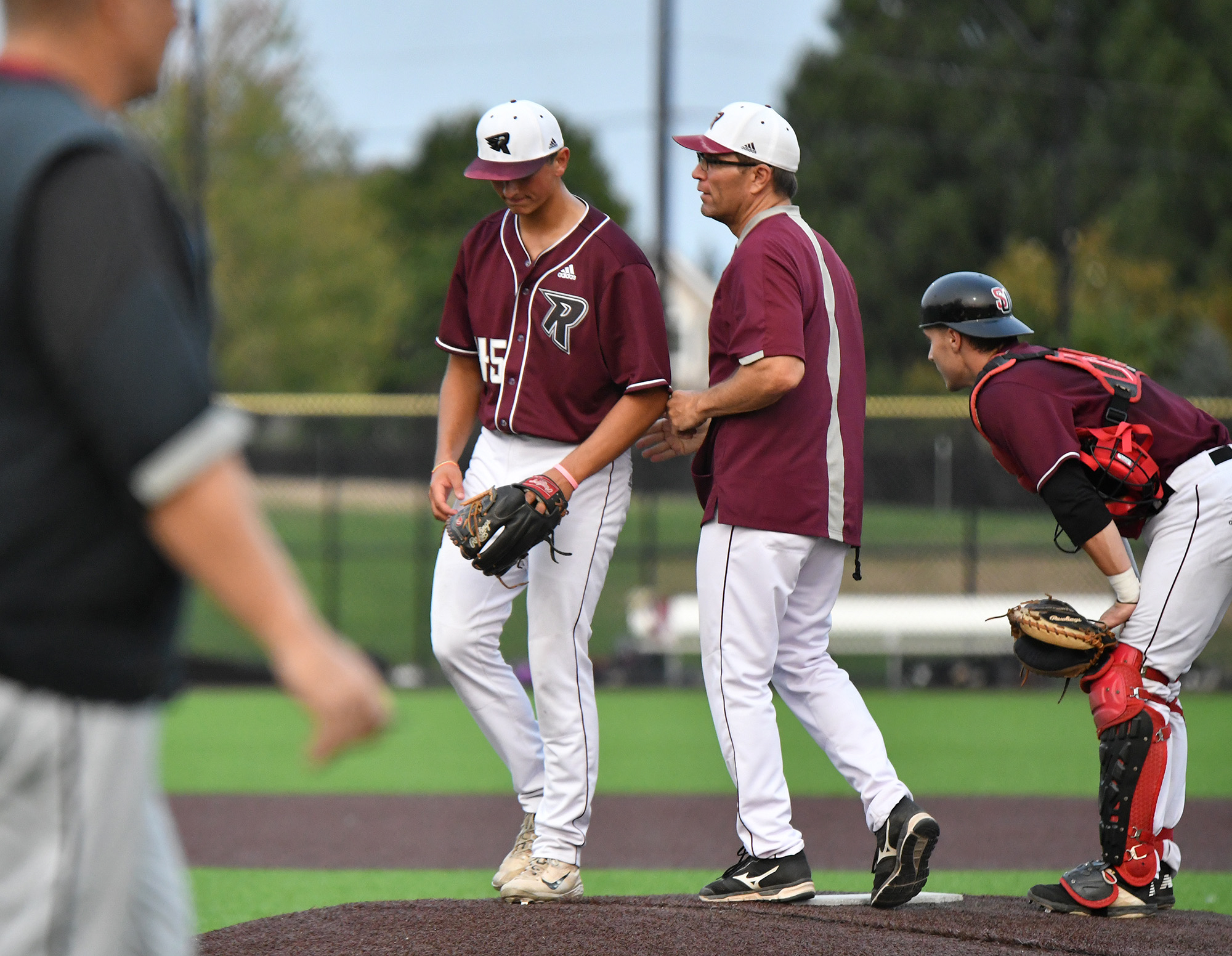 Ridgefield pitcher Brock Gillis, left, walks back to the dugout after getting pulled Saturday, Aug. 14, 2021, during the Raptors' 13-6 loss to Corvallis in a playoff game at the Ridgefield Outdoor Recreation Complex.