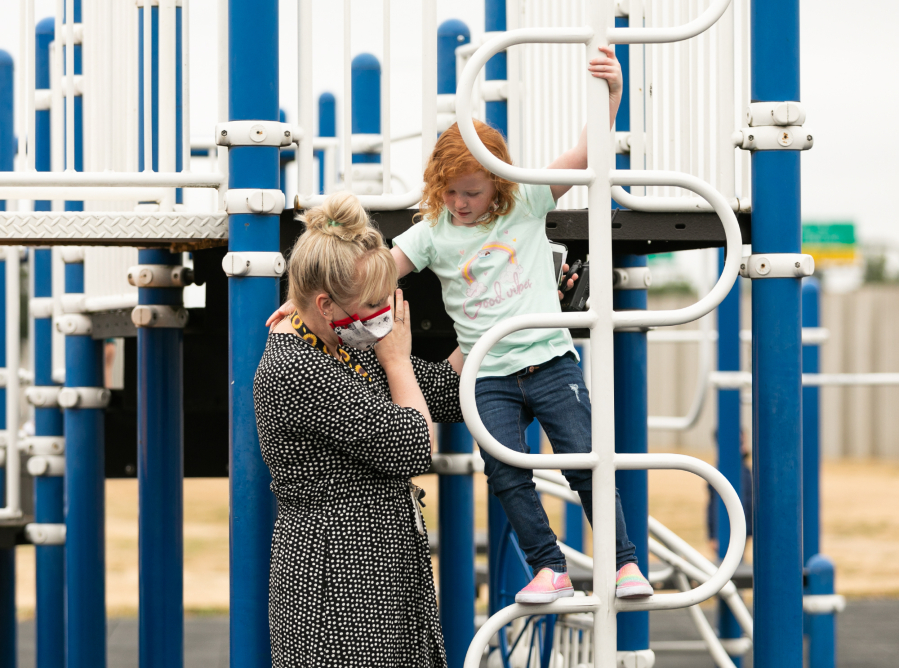 Hazel Dell Elementary principal Lisa Reed helps incoming kindergartener Raylynn Collins off of the jungle gym during recess at Jump Start, Vancouver Public Schools' program for incoming kindergartners, on Wednesday. All of Clark County school districts saw enrollment declines in 2020-21 because of COVID-19 concerns and are hoping for enrollment rebounds when school begins Aug. 31. Reed said about 20 percent of kindergartners get registered for enrollment by their families the final week of summer.