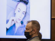 Defendant David Bogdanov listens to the prosecution's opening statement, with a photo of 17-year-old Nikki Kuhnhausen on a projection screen behind him, at his murder trial Tuesday morning in Clark County Superior Court. Bogdanov is accused of strangling the transgender teen.