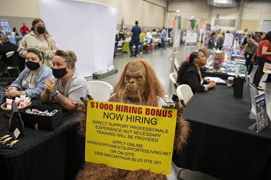 A person dressed as Sasquatch greets those seeking employment at a job fair in August 2021. The fair drew more than 100 employers looking to meet with job seekers to the Clark County Event Center at the Fairgrounds. At top, Henry Pio of Hazel Dell, from left, talks with Congresswoman Jaime Herrera Beutler as she greets his stepdaughter, Geovanna Alarcon, who is looking for employment.