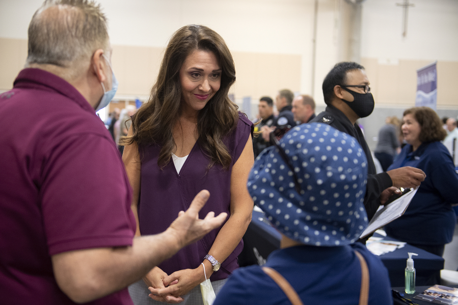 Henry Pio of Hazel Dell, from left, talks with Congresswoman Jaime Herrera Beutler as she greets his stepdaughter, Geovanna Alarcon, who is looking for employment, during a job fair at the Clark County Event Center in August.