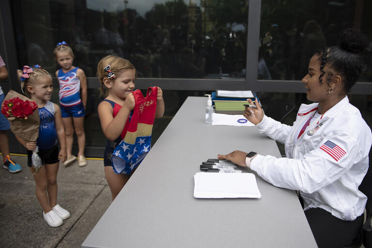 Young gymnasts Hadley Cherry, 3, from left, Quinn Cherry, 5, and Eliora Bertsch, 5, wait in line outside Vancouver City Hall for an autograph from 2020 Olympic Games silver medal winning gymnast Jordan Chiles following the parade in her honor on Sunday afternoon, Aug. 22, 2021.