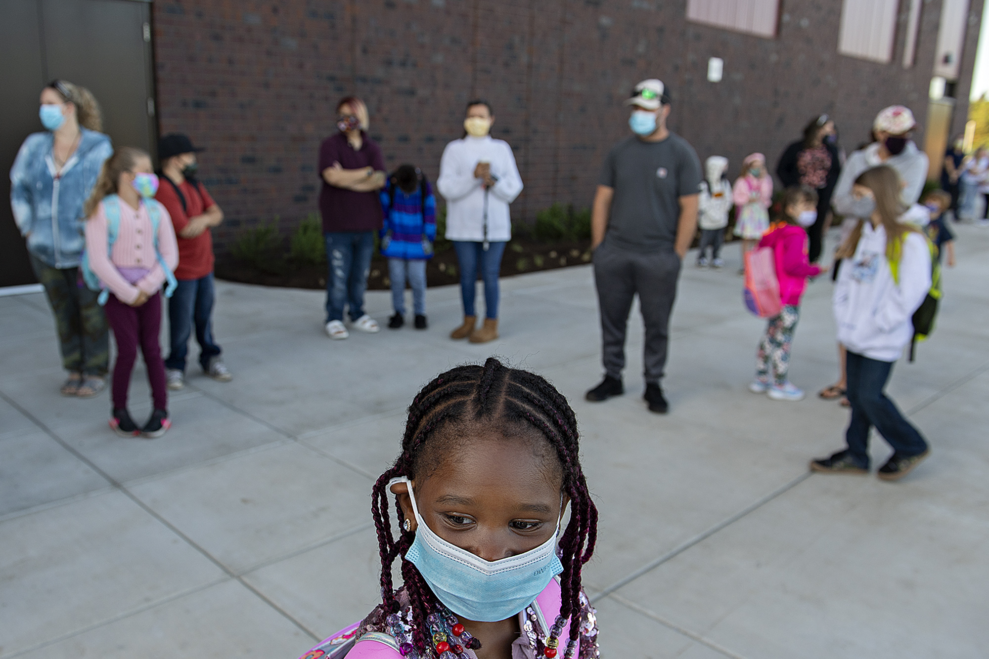 Second-grader Mariama Sandy, 7, front, wears a face mask as she waits outside Marrion Elementary School with fellow students for the first day of class Tuesday morning, Aug. 31, 2021.