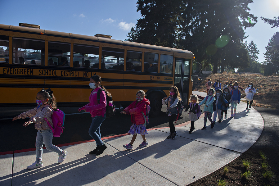 Young students practice social distancing after leaving the school bus for their first day of class at Marrion Elementary School on Tuesday. Thousands of students across multiple Clark County school districts, including Evergreen and Vancouver, began classes for the 2021-22 school year Tuesday amid another year impacted by COVID-19. More districts start Wednesday.