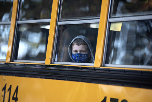 First-grader Alishan Krekic peeks out from his spot on the school bus as he arrives for classes at Marrion Elementary School on Tuesday morning, Aug. 31, 2021.