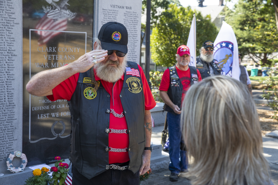 Patriot Guard Rider Nick Kinler salutes Amber Howard, widow of U.S. Army National Guard Sgt. Bryce D. Howard, after presenting her with a tracing of her husband's name on an Illinois war memorial during a ceremony honoring the fallen soldier's memory Saturday at the Clark County Veterans War Memorial. Amber accepted the gift with her sons, Caleb, 21, and Ryen, 17.