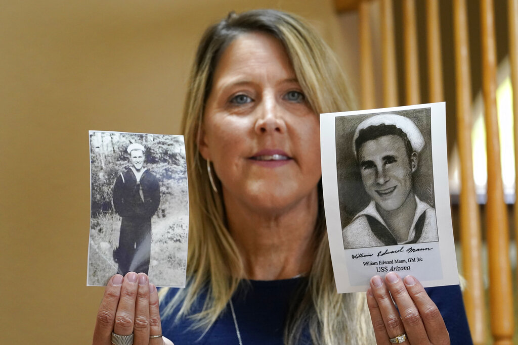 Teri Mann Whyatt displays photos of her uncle, William Edward Mann, who died on the USS Arizona during the bombing of Pearl Harbor, at her home Wednesday, July 14, 2021, in Newcastle, Wash. In recent years, the U.S. military has taken advantage of advances in DNA technology to identify the remains of hundreds of sailors and Marines who died in the 1941 bombing of Pearl Harbor and has sent them home to their families across the country for burial. The remains of 85 unknowns from the USS Arizona, which lost more men during the attack than any other ship, haven't received this treatment, however.