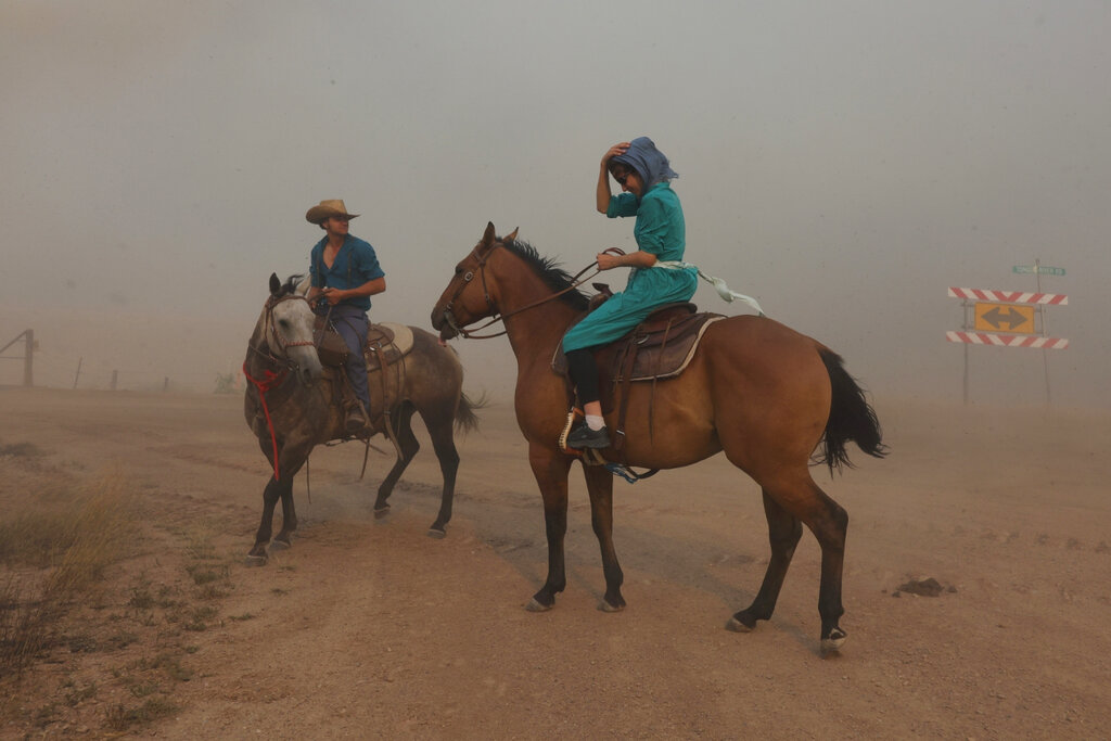 Isaac Slabaugh and Fannie Stutzman are surrounded by smoke from the Richard Spring Fire as it moves toward Ashland, Mont., Tuesday, Aug. 10, 2021. The fire burning on and around the Northern Cheyenne Indian Reservation has grown into Montana's largest blaze so far in 2021.