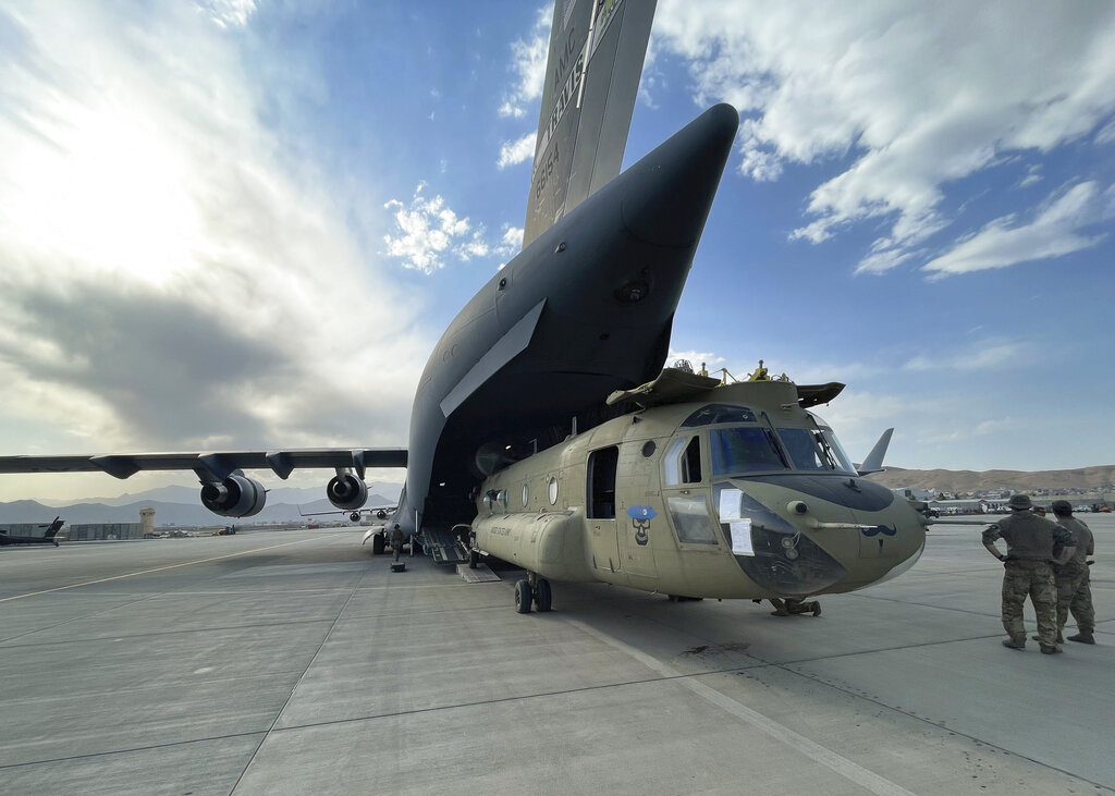 In this image provided by the Department of Defense, a CH-47 Chinook from the 82nd Combat Aviation Brigade, 82nd Airborne Division is loaded onto a U.S. Air Force C-17 Globemaster III at Hamid Karzai International Airport in Kabul, Afghanistan, Saturday, Aug, 28, 2021.