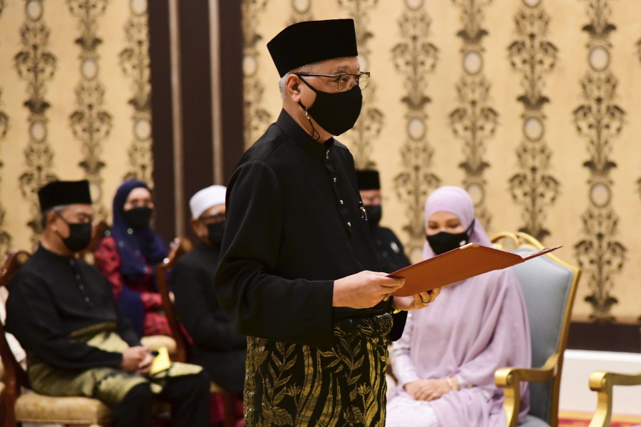 In this photo released by Malaysia's Department of Information, Malaysia's incoming Prime Minister Ismail Sabri Yaakob takes the oath of office during his swearing-in ceremony as the country's new leader at the National Palace in Kuala Lumpur.