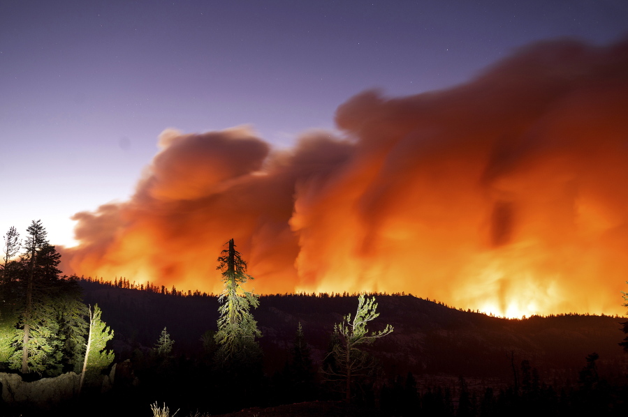 Seen in a long camera exposure, the Caldor Fire burns on Sunday, Aug. 29, 2021, in Eldorado National Forest, Calif.