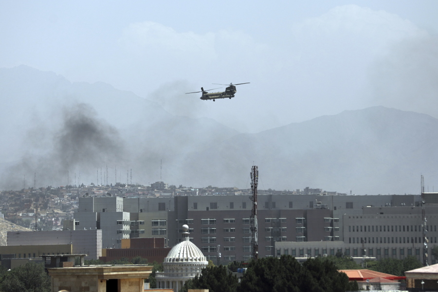 A U.S. Chinook helicopter flies over the city of Kabul, Afghanistan, Sunday, Aug. 15, 2021. Taliban fighters entered the outskirts of the Afghan capital on Sunday, further tightening their grip on the country as panicked workers fled government offices and helicopters landed at the U.S. Embassy.