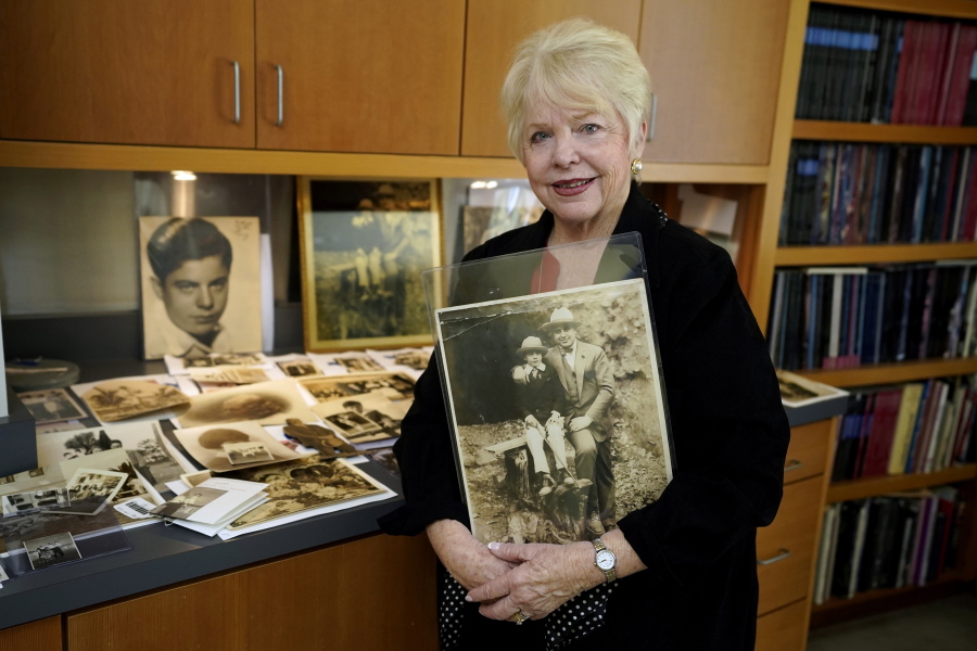 Diane Capone holds a copy of a photograph of her father, Albert "Sonny" Capone as a young boy and her grandfather Al Capone on display at Witherell's Auction House in Sacramento, Calif., Wednesday, Aug. 25, 2021. The granddaughter of the famous mob boss and her two surviving sisters will sell 174 family heirlooms at an Oct. 8 auction titled "A Century of Notoriety: The Estate of Al Capone," that will be held by Witherell's in Sacramento.