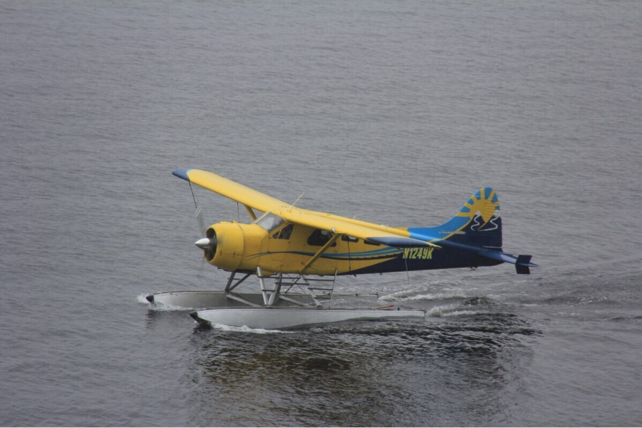 This Thursday, Aug. 5, 2021, photo provided by Lee LaFollette shows a de Havilland Beaver aircraft departing the Port of Ketchikan, Alaska. Foggy, reduced-visibility conditions have delayed efforts to recover the wreckage of a sightseeing plane that crashed in southeast Alaska, killing six people. Clint Johnson, chief of the National Transportation Safety Board's Alaska region, says the agency had hoped to recover the wreckage Sunday. But he says those efforts were called off due to poor conditions. He says the crew planned to try again on Monday, Aug. 9, 2021.