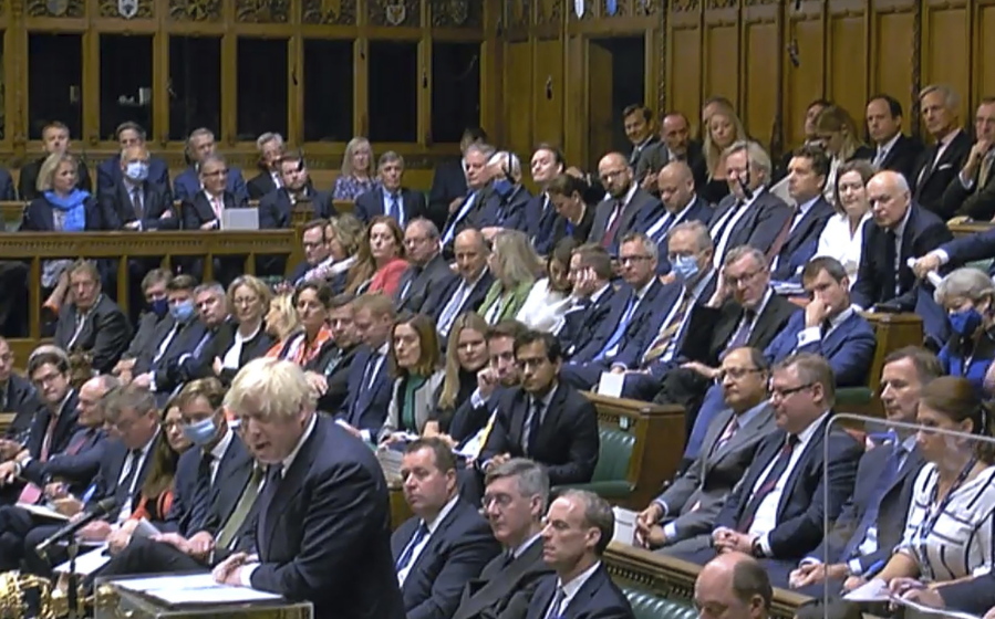 Britain's Prime Minister Boris Johnson speaks during the debate on the situation in Afghanistan inside parliament in London, as lawmakers attend an emergency sitting three days after the Afghanistan capital Kabul fell to the Taliban. Nearly all ruling Conservative Party lawmakers were not wearing face masks during the debate Wednesday, while opposition Labour Party lawmakers sat in parliament nearly all wearing face masks.