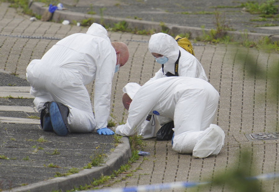 Forensic officers work in Biddick Drive in the Keyham area of Plymouth, England Friday Aug. 13, 2021 where six people were killed in a shooting incident. Police in southwest England say several people were killed, including the suspected shooter, in the city of Plymouth in a "serious firearms incident" that wasn't terror-related.