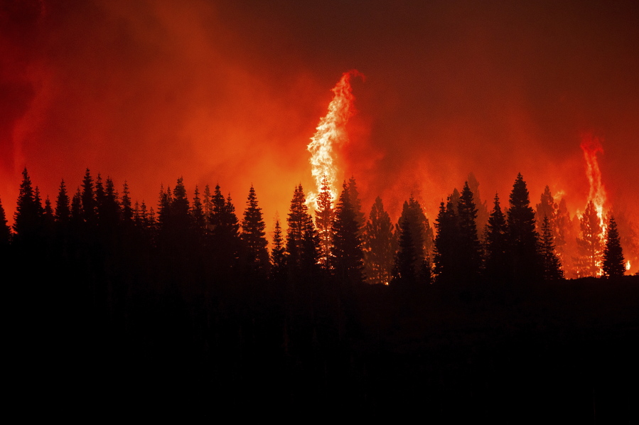 Flames from the Dixie Fire crest a hill in Lassen National Forest, Calif., near Jonesville on Monday, July 26, 2021.