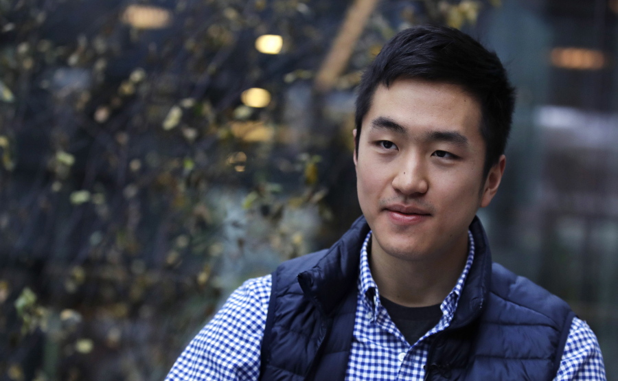 FILE-- In this Dec. 13, 2018 file photograph, Harvard University graduate and Rhodes Scholar Jin K. Park, who holds a degree in molecular and cellular biology, listens during an interview in Cambridge, Mass. Park, the first "Dreamer" to be awarded a prestigious Rhodes Scholarship, finally is heading to England's University of Oxford this fall after 2 1/2 years of limbo brought on by the Trump administration's refusal to let DACA recipients travel abroad.