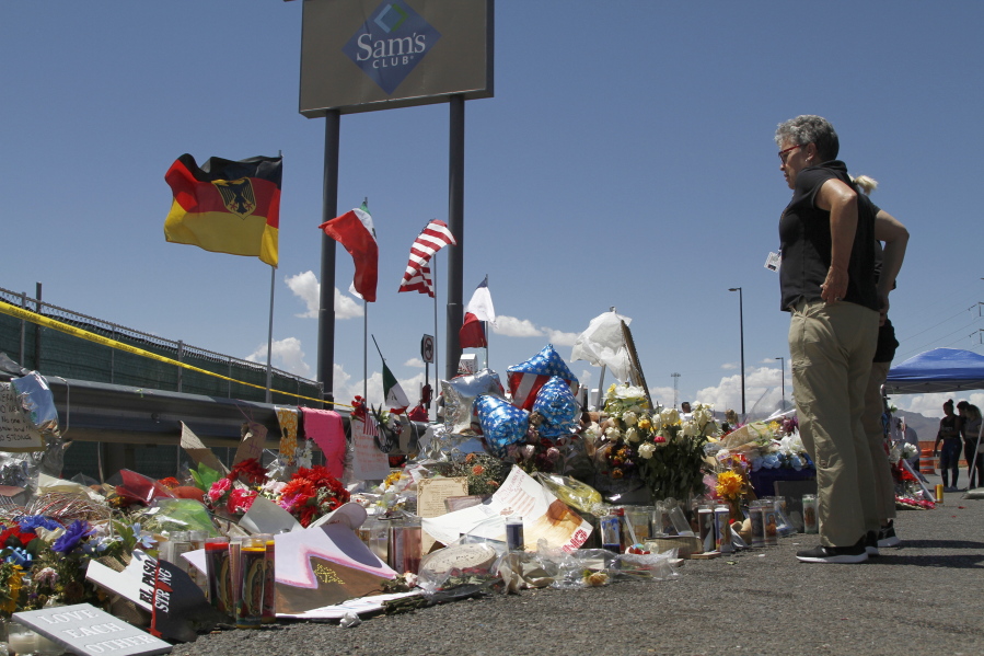 FILE - In this Aug. 12, 2019 photo, mourners visit the makeshift memorial near the Walmart in El Paso, Texas, where 22 people were killed in a mass shooting.  Officials in the border city are unveiling a garden meant to bring healing two years after a gunman targeting Latinos opened fire, ultimately killing 23 people in an attack that stunned the U.S. and Mexico.
