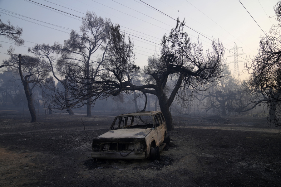 A burned car is seen after a wildfire in Varibobi area, northern Athens, Greece, Wednesday, Aug. 4, 2021. More than 500 firefighters struggled through the night to contain a large forest blaze on the outskirts of Athens, which raced into residential areas Tuesday, forcing thousands to flee. It was the worst of 81 wildfires that broke out in Greece over the past 24 hours, amid one of the country's most intense heatwaves in decades.