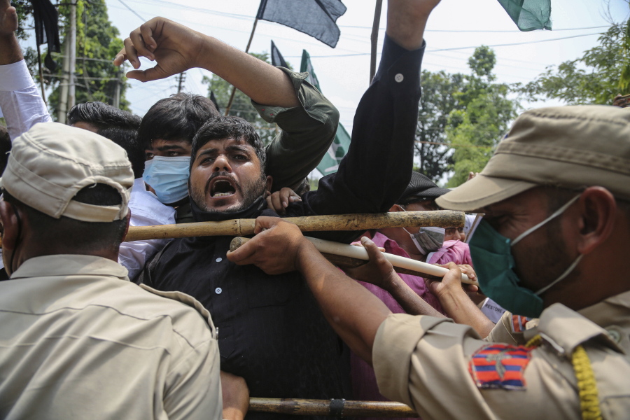 Activists of Peoples Democratic Party scuffle with police during a protest marking the second anniversary of Indian government scrapping Kashmir's semi- autonomy in Jammu, India, Thursday, Aug.5, 2021. On Aug. 5, 2019, Indian government passed legislation in Parliament that stripped Jammu and Kashmir's statehood, scrapped its separate constitution and removed inherited protections on land and jobs.