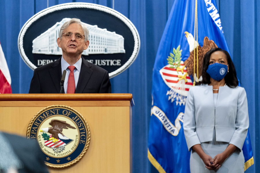Assistant Attorney General for Civil Rights Kristen Clarke, right, accompanied by Attorney General Merrick Garland, left, speaks at a news conference at the Department of Justice in Washington, Thursday, Aug. 5, 2021, to announce that the Department of Justice is opening an investigation into the city of Phoenix and the Phoenix Police Department.