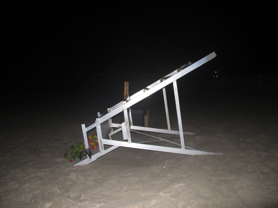 A lifeguard chair sits overturned on the sand at the beach in Berkeley Township, N.J., where a young lifeguard was killed and seven others injured by a lightning strike, Monday, Aug. 30, 2021.