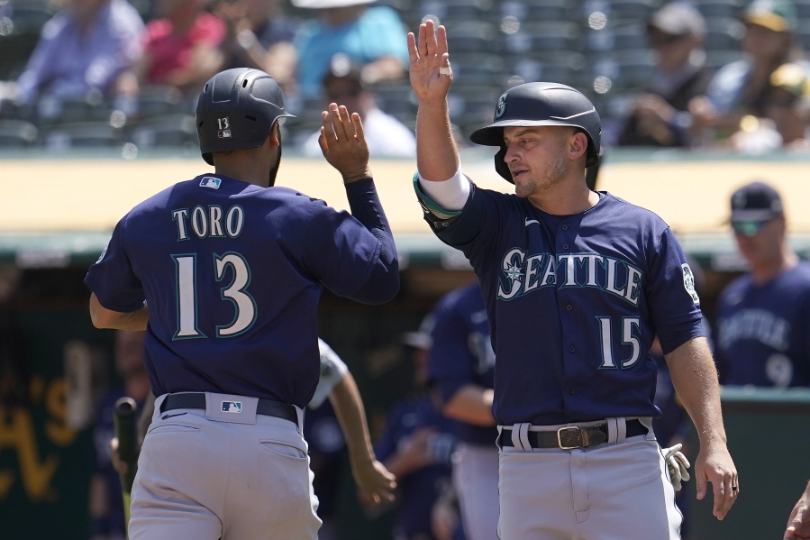Seattle Mariners' Abraham Toro, left, celebrates with Kyle Seager after both scored on a two-run single by Luis Torrens during the third inning of a baseball game against the Oakland Athletics in Oakland, Calif., Tuesday, Aug. 24, 2021.