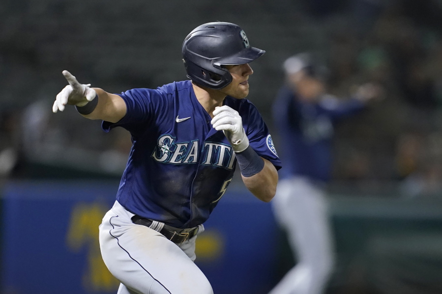 Seattle Mariners' Jake Bauers reacts after hitting a two-run single against the Oakland Athletics during the ninth inning of a baseball game in Oakland, Calif., Monday, Aug. 23, 2021.