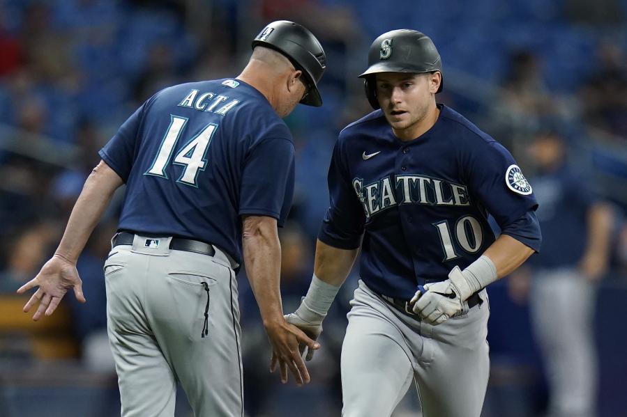 Seattle Mariners' Jarred Kelenic (10) celebrates with third base coach Manny Acta (14) after his solo home run off Tampa Bay Rays pitcher Luis Patino during the fourth inning of a baseball game Tuesday, Aug. 3, 2021, in St. Petersburg, Fla.