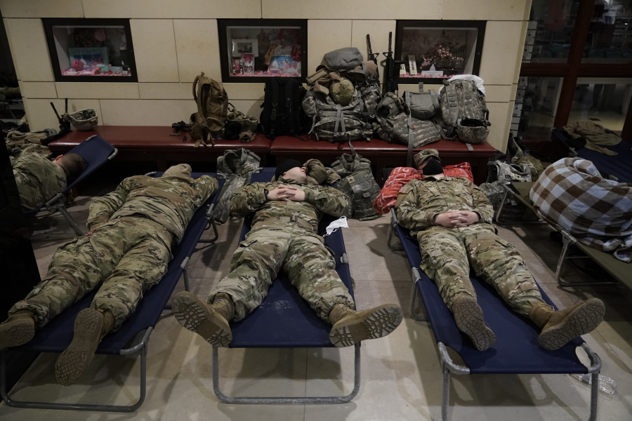 FILE - In this Jan. 18, 2021, file photo National Guard troops sleep inside the Capitol Visitor's Center at the Capitol in Washington. Over the past year, National Guard members have been called in to battle the COVID-19 pandemic, natural disasters and race riots. (AP Photo/J.