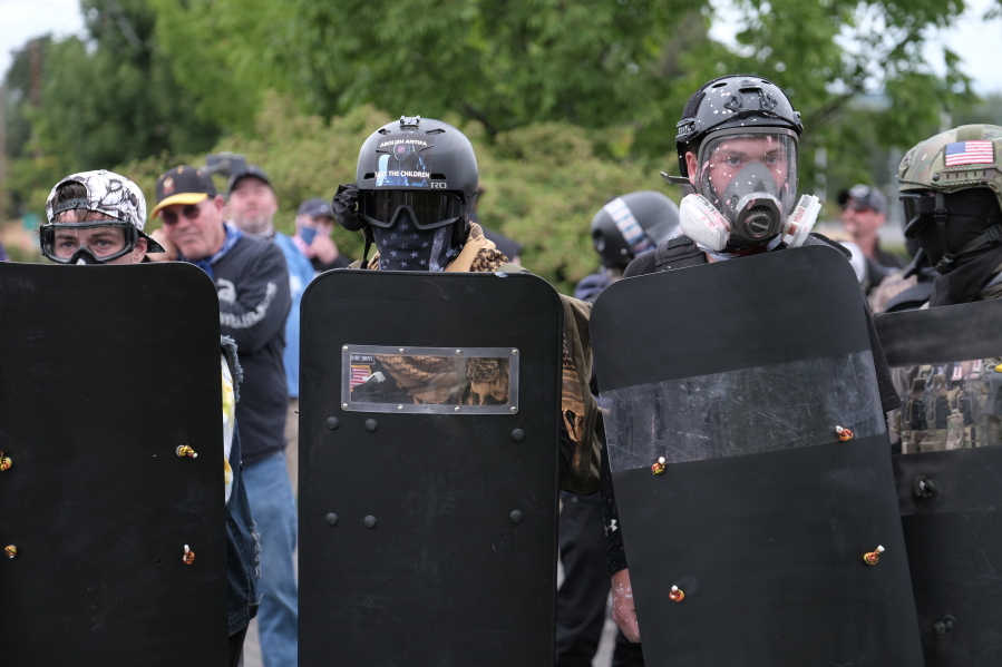 Member of the far-right group Proud Boys take a defensive formation and hold shields as they face off with anti-fascist counter-protesters on Sunday, Aug. 22, 2021, in Portland, Ore.