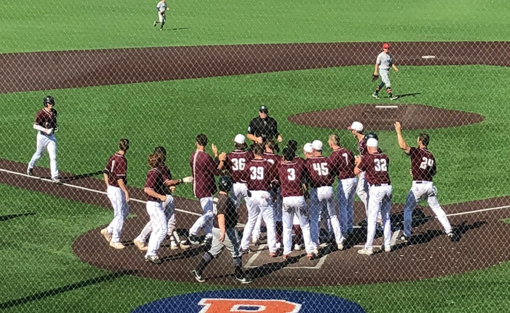 The Ridgefield Raptors await John Peck at home plate after his game-winning home run in the 11th inning against the Walla Walla Sweets on Sunday at Ridgefield Outdoor Recreation Complex.