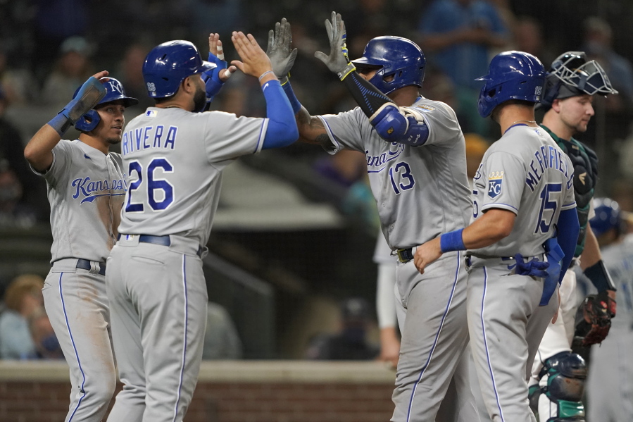 Kansas City Royals' Salvador Perez (13) is greeted at the plate by Emmanuel Rivera (26) after Perez hit a grand slam against the Seattle Mariners during the sixth inning of a baseball game Thursday, Aug. 26, 2021, in Seattle. (AP Photo/Ted S.