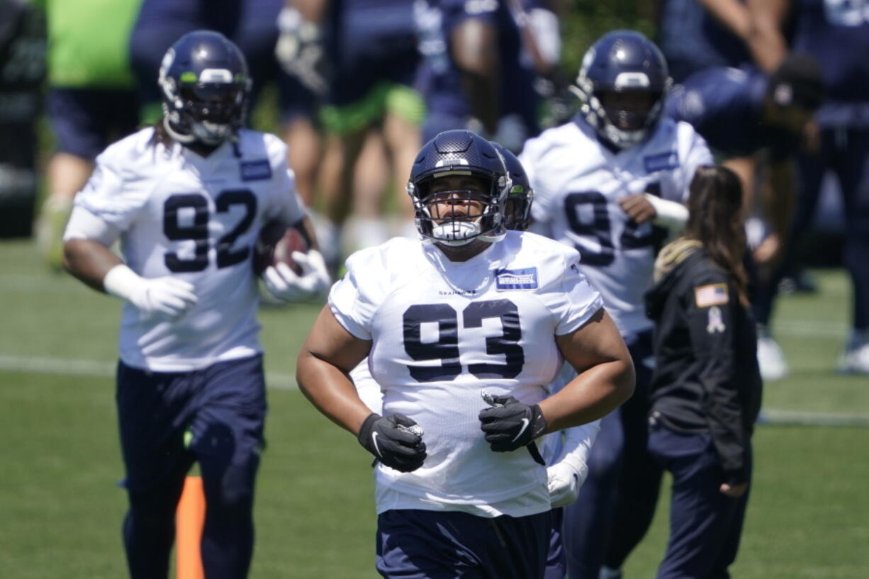 FILE - In this June 16, 2021, file photo, Seattle Seahawks' Al Woods (93) runs between drills during NFL football practice in Renton, Wash. Woods always intended to continue his NFL career, even when he decided to join the small pool of players who opted out of the 2020 season due to the COVID-19 pandemic. (AP Photo/Ted S.