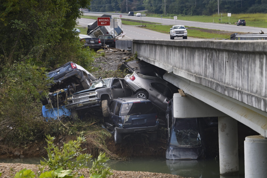 Cars are stacked on top of each other on the banks of Blue Creek being swept up in flood water, Monday, Aug. 23, 2021, in Waverly, Tenn. Heavy rains caused flooding in Middle Tennessee days ago and have resulted in multiple deaths as homes and rural roads were washed away.