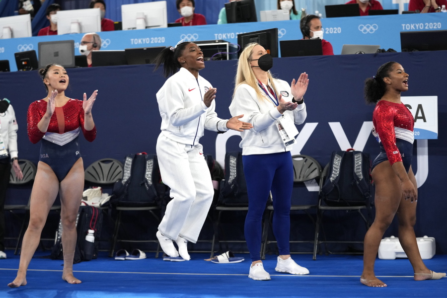 FILE - In this July 27m 2021 file photos, gymnasts from the United States, Simone Biles, center, Jordan Chiles , right, and Sunisa Lee cheer Grace McCallum as she performs on the floor during the artistic gymnastics women's final at the 2020 Summer Olympics, in Tokyo. Biles and Naomi Osaka are prominent young Black women under the pressure of a global Olympic spotlight that few human beings ever face. But being a young Black woman -- which, in American life, comes with its own built-in pressure to perform -- entails much more than meets the eye.